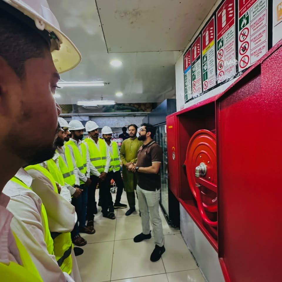 Trainer briefing trainees on a fire hose reel